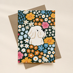 Greeting card with a white terrier dog surrounded by colorful flowers on a patterned background