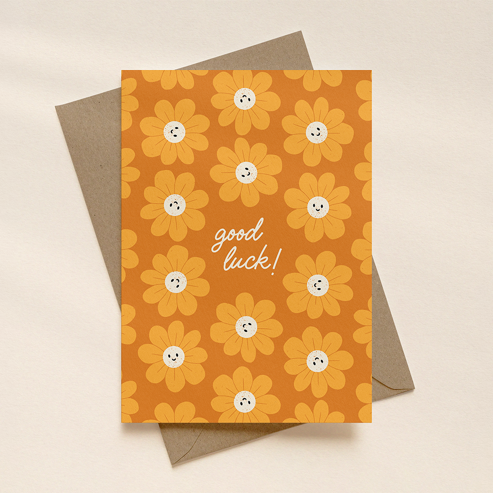 Greeting card with floral pattern and 'good luck!' text on a beige background