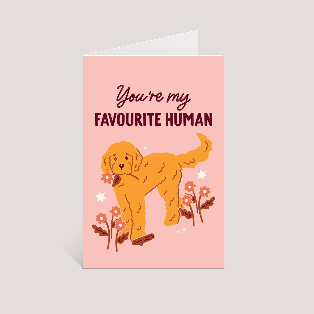 Greeting card with a dog illustration and text 'You're my favourite human' on a pink background
