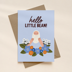 Greeting card with illustration of a baby and flowers, text 'hello little bean!', on a beige background.
