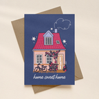 Greeting card with a house illustration and 'home sweet home' text on a blue background, featuring a brown envelope.