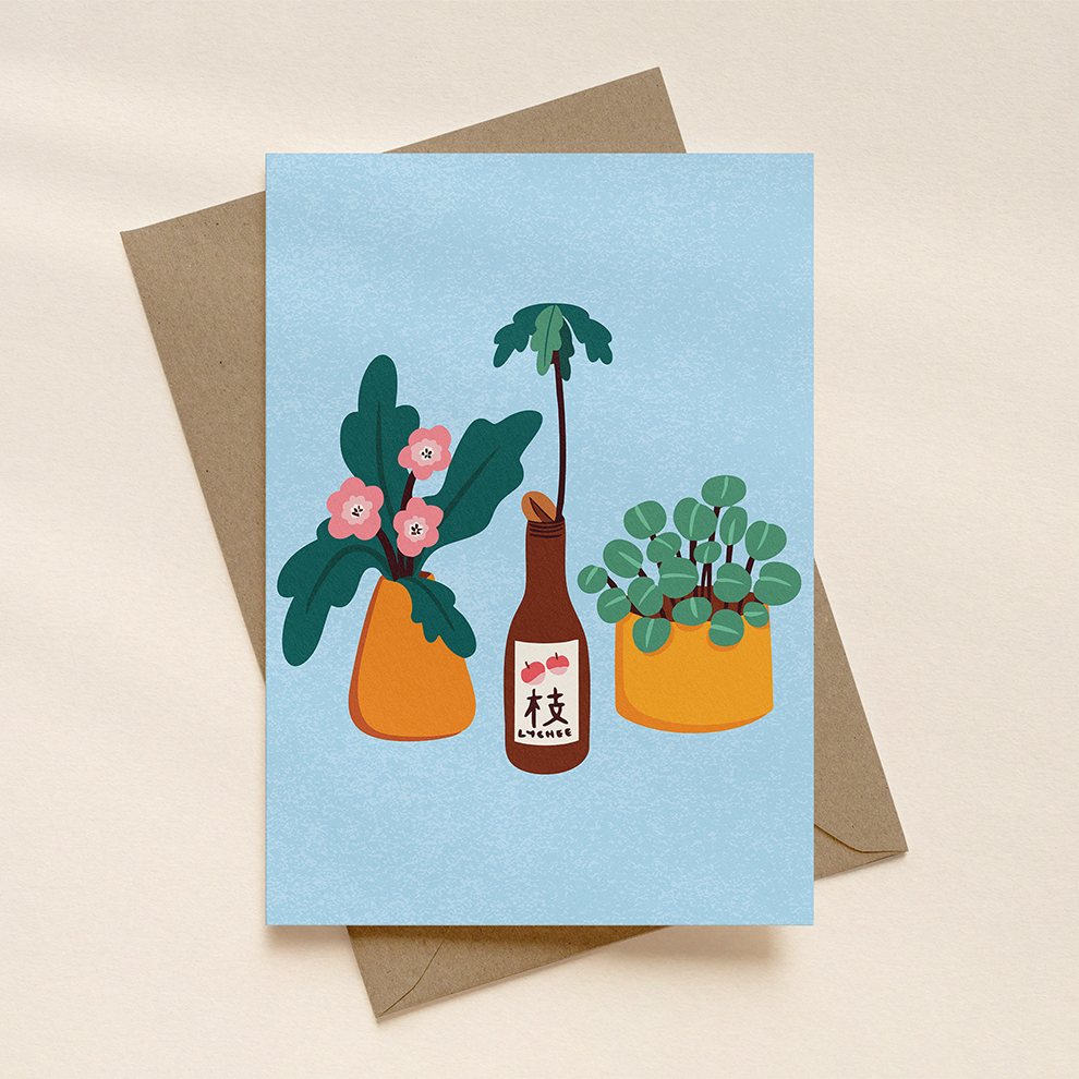 Greeting card with plant illustrations on a light blue background, placed on a beige surface.