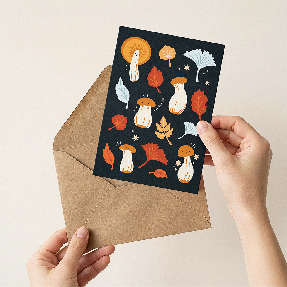 Greeting card with autumn-themed design held over a brown envelope
