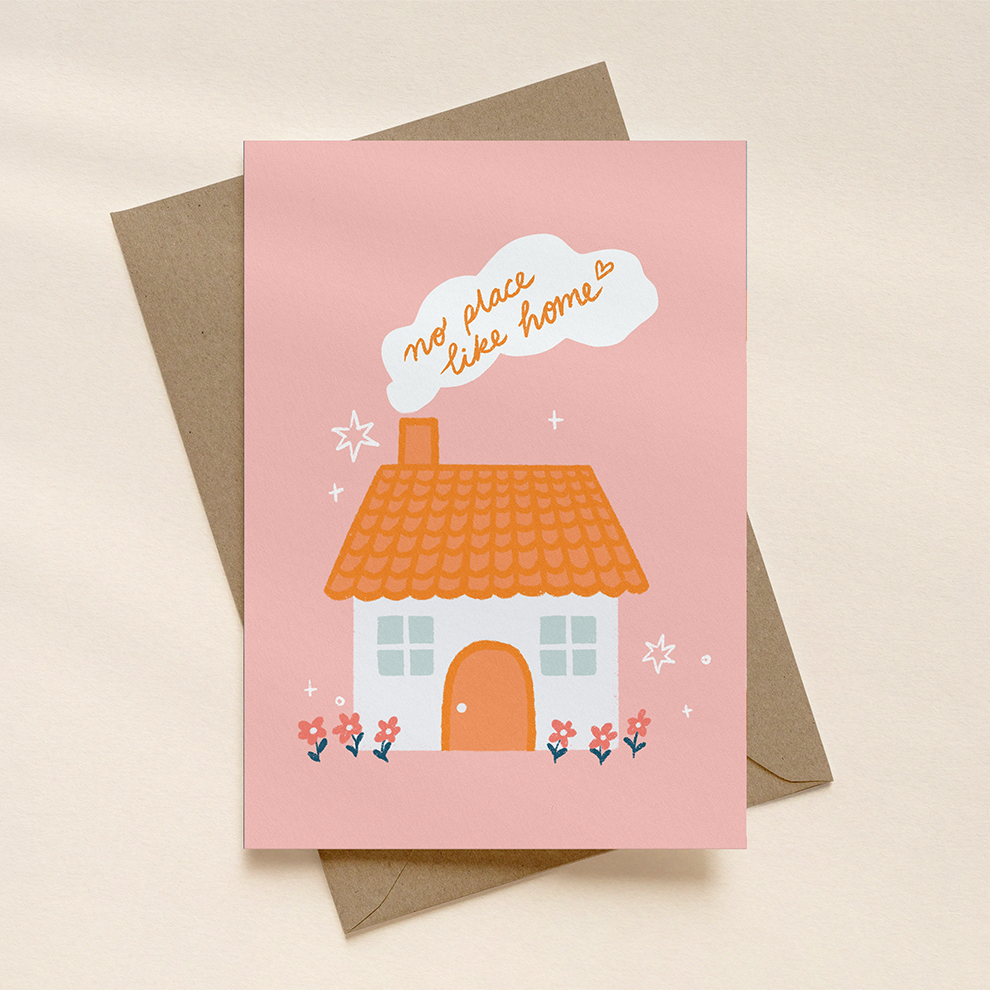 Greeting card with a house illustration and 'no place like home' text on a pink background