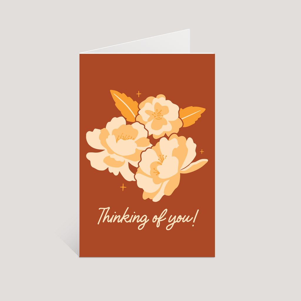 Greeting card with floral design and 'Thinking of you!' text on a brown background