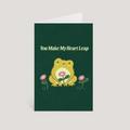 Greeting card with a frog illustration and text 'You Make My Heart Leap' on a green background.