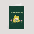 Greeting card with a frog illustration and text 'You Make My Heart Leap' on a green background.
