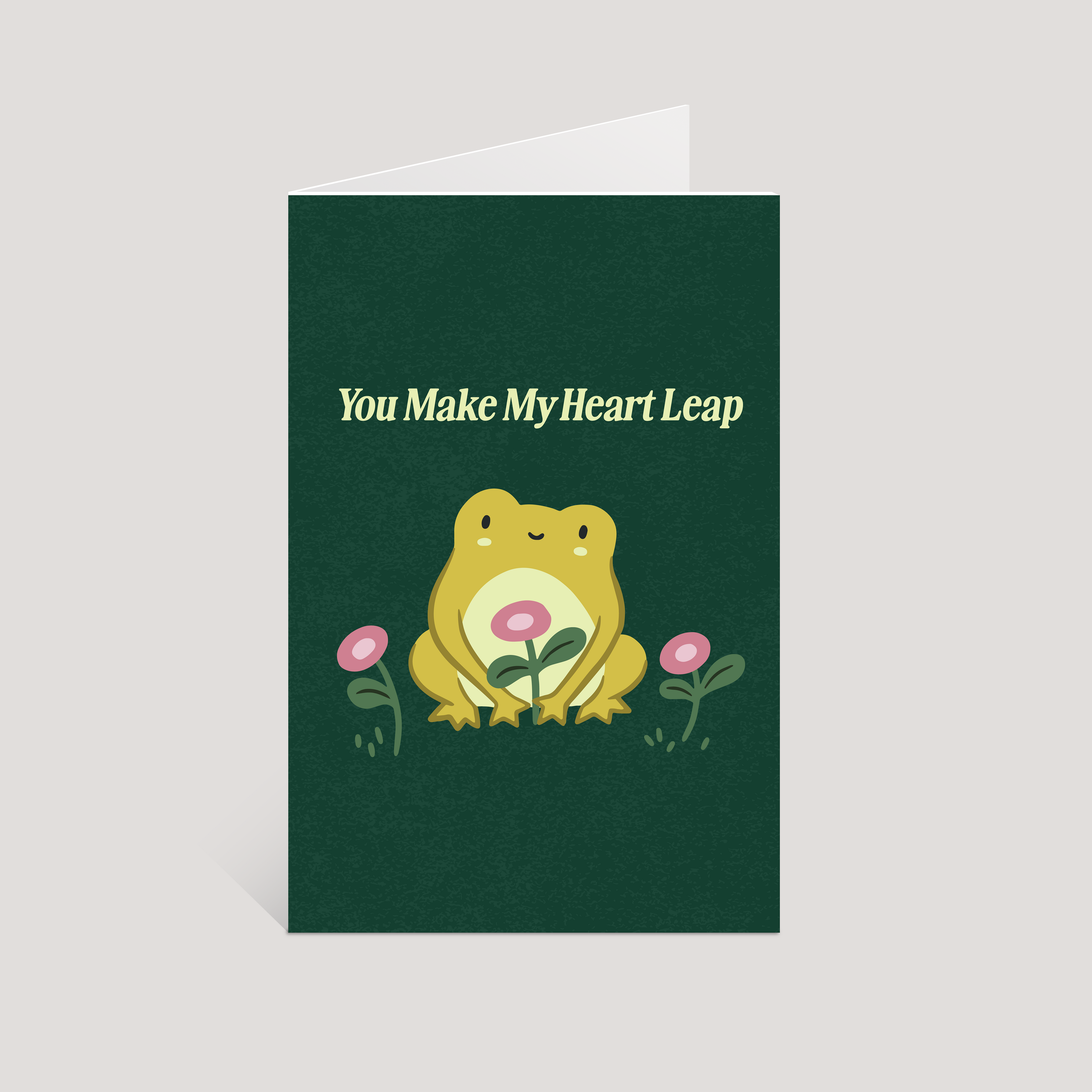 Greeting card with a frog illustration and text 'You Make My Heart Leap' on a green background.