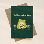 Greeting card with a frog illustration and text 'You Make My Heart Leap' on a beige background